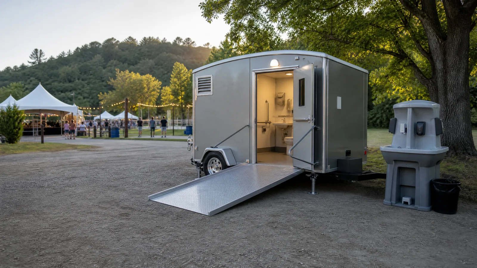 Accessible portable restroom beside a firm, unobstructed path at an outdoor gathering